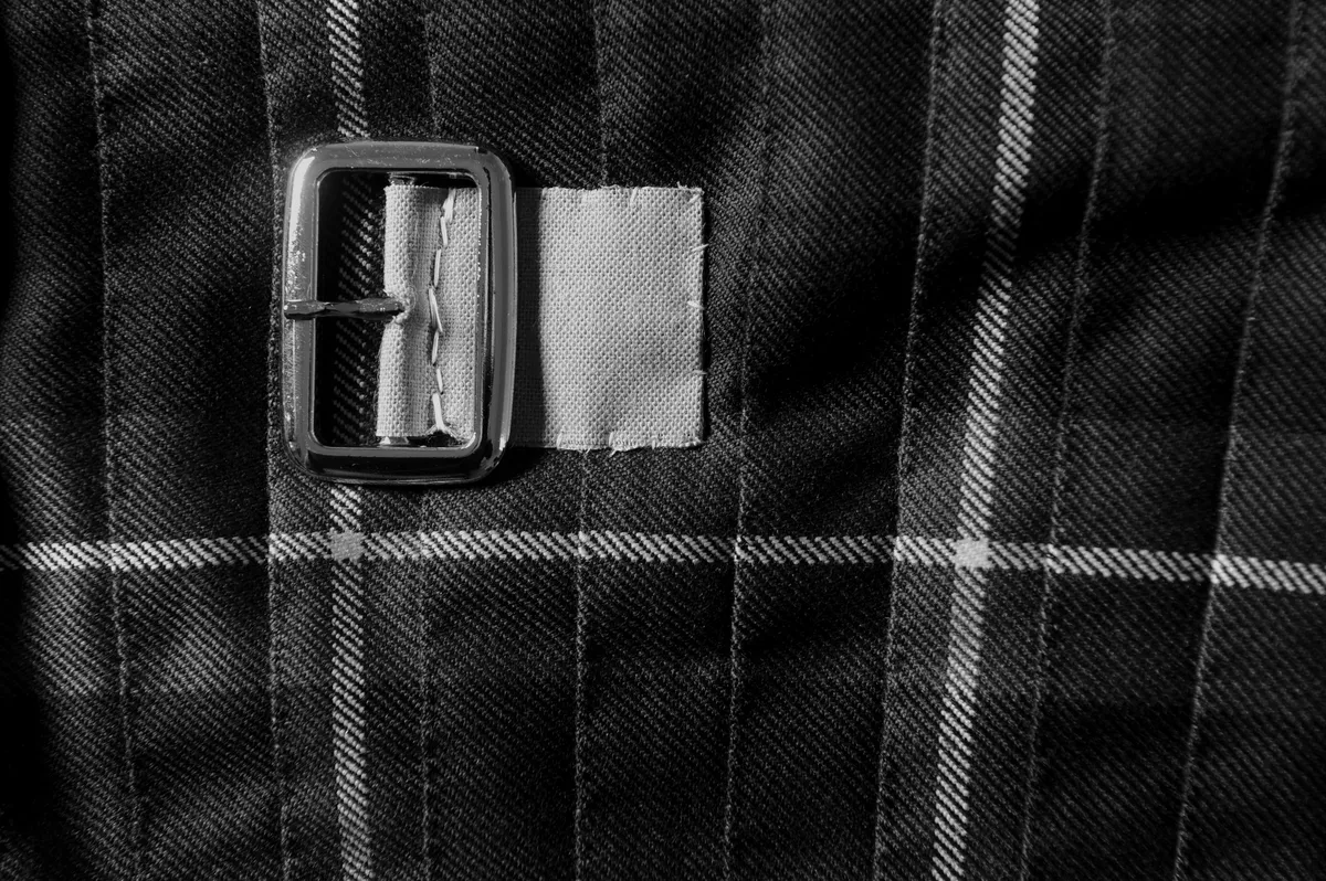 A leather strap and buckle on the kilt apron