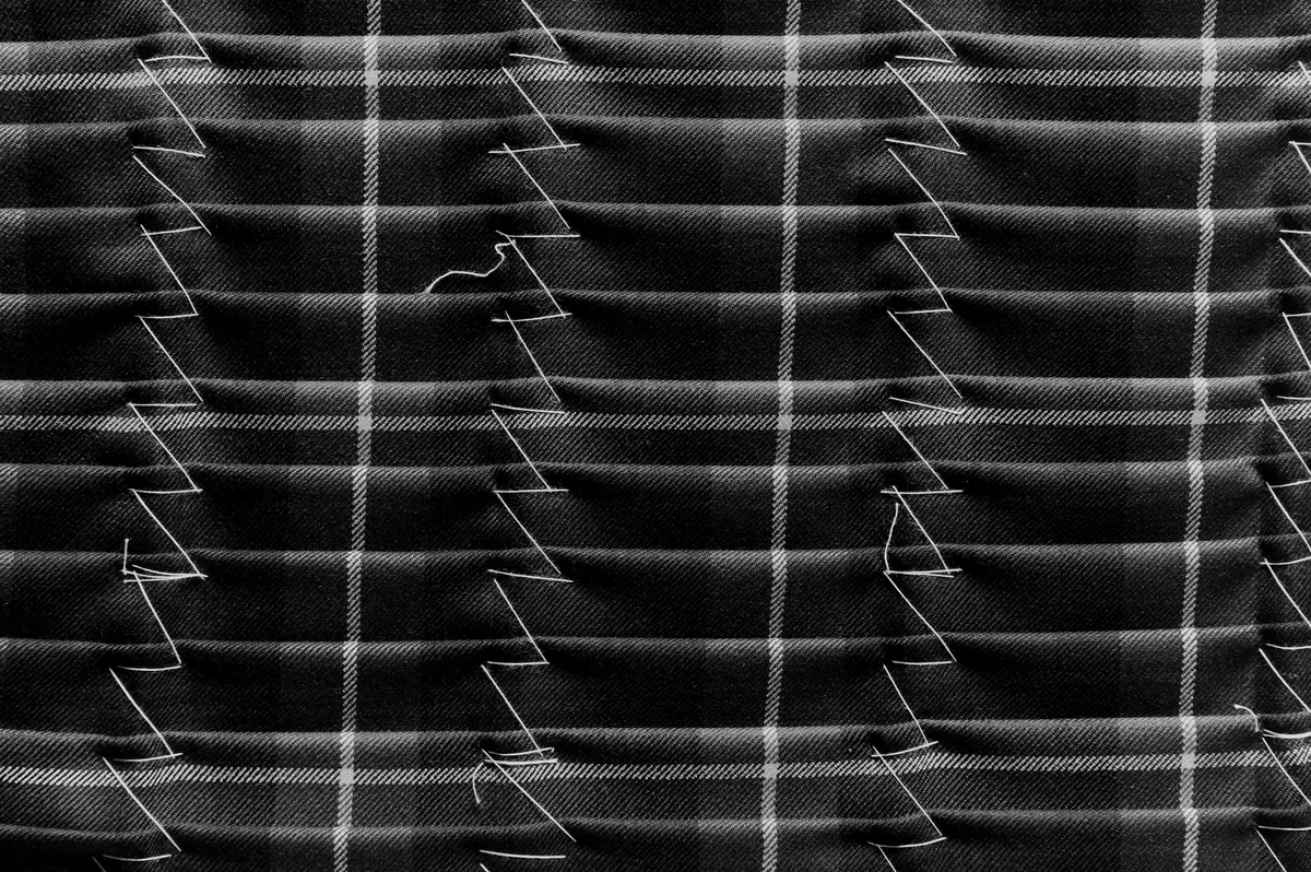 Tartan pleats held with hand-basting stitches